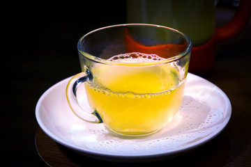 Cup of fruit tea on a wooden table in a cafe.