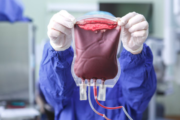 Hands of a medical worker holding a bag of donor blood
