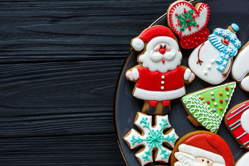 Handmade Gingerbread cookies for Christmas, New year on the plate on wooden table. Festive, sweet pastry, delicious biscuits. Home celebration, decoration concept