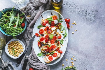 Italian bruschetta with chopped tomatoes, basil and mozzarella on grilled crusty bread