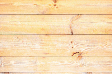 Yellow wooden boards or planks untreated and rustic, suitable as background or ground. The wood is rough and has knotholes.