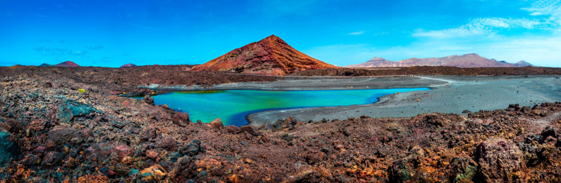 Impressive and scenic volcanic nature unique in Timanfaya National Park.Red mountain and green puddle near the sea coast in Canary island,Lanzarote.Spain beachs