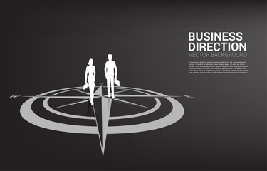 Silhouette of businessman and businesswoman walk forward on center of compass on floor .Concept of career path and business direction © Panithan