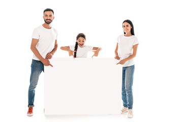 happy parents and kid pointing with fingers at blank placard isolated on white