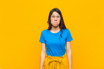 young pretty latin woman feeling sad and stressed, upset because of a bad surprise, with a...