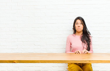 young  pretty latin woman feeling sad and stressed, upset because of a bad surprise, with a...