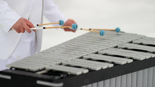 Handsome Man playing the vibraphone in snow with white suit