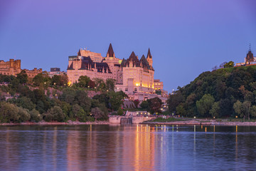 Obraz premium A large building on a river at dusk