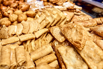 a showcase with bread pastries, a lot of different products from flour, sausage in pastry, pasties, bagels, cheesecakes