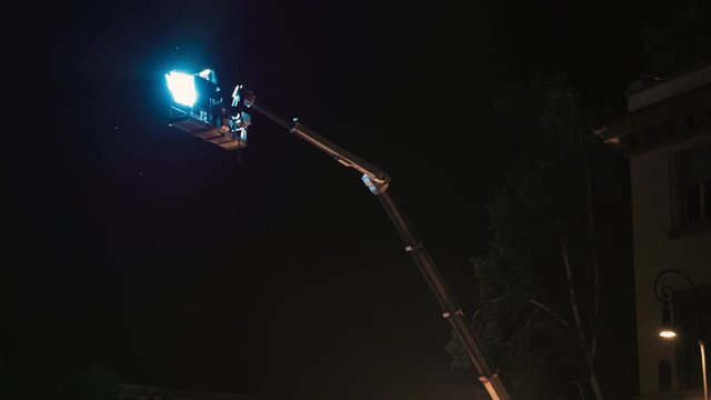 Spotlight for filming movie at the street. Light equipment for shooting different scenes at night outdoors. Optical flashlight switching on and off. Video production in 4K