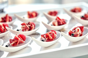 Delicious canapes hamon with raspberries. Concept of food, restaurant, catering, menu.