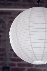 Asian oriental style thin white paper LED CFL bulb lantern for party decorative ball hanging from above in portrait orientation