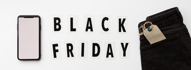 Creative promotion composition Black friday text and jeans on white background. Flat lay, top view, overhead, mockup, template. Minimal abstract background. Online shopping, sale, promo. Web banner