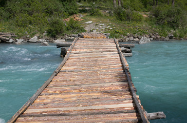 Wooden bridge over the mountain river.