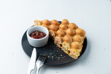Hong Kong bubble waffle with sausage and cheese on white flat lay