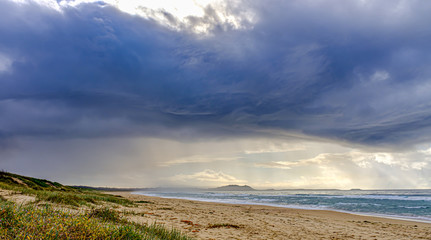 Dark storm cloud and rain over beach NSW Australia