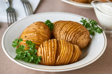 Baked potatoes with parsley on a white plate