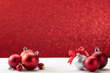 christmas balls on white table red wall