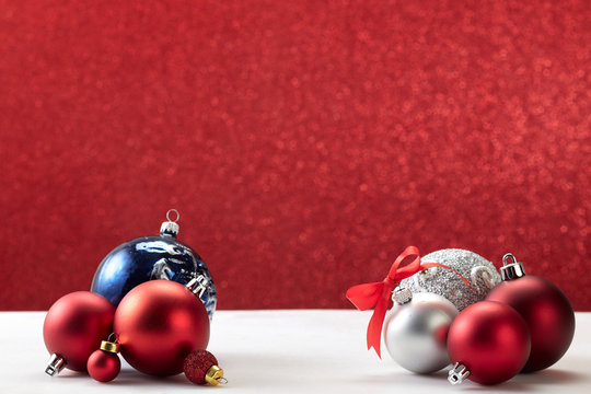 Christmas Balls On White Table Red Wall