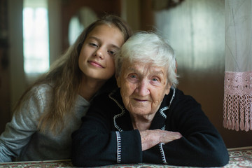Portrait of elderly grandmother with her little granddaughter.