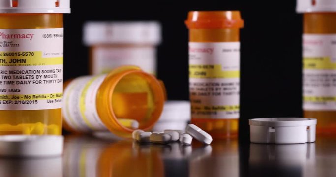 Slow Panning of Non-proprietary Medicine Bottles and Pills on Dark Wood Surface