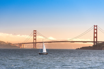 Fototapeta na wymiar Golden gate bridge sunset with sailboat