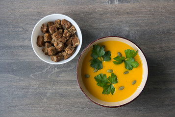 Pumpkin cream soup with parsley, pumpkin seeds and breadcrumbs