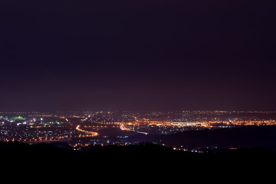 Aerial night view of a countryside. Beautiful landscape panorama at night. Aerial view city on the mountain.