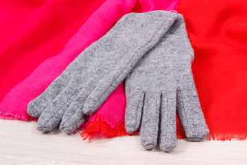 Gloves and shawl on board, warm womanly clothing for autumn or winter