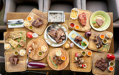 Barbecue restaurant menu. Many different food on the table. Dinner party or Banquet. Top view