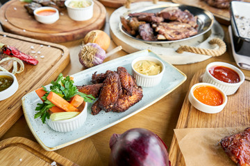 Chicken wings fries. Barbecue restaurant menu. Many different food on the table. Dinner party or Banquet.