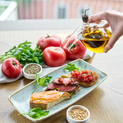 Bruschetta with beef, tomatoes and salmon.. Variety of dishes on the table. Various snacks and antipasti on the table. Restaurant menu. Italian cuisine