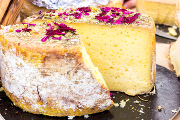 Various varieties of hard cheese on a wooden board. View from above.