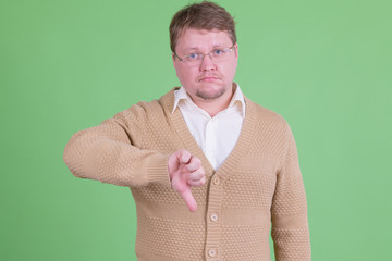 Stressed overweight bearded man giving thumbs down © Ranta Images