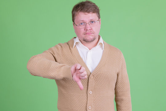 Stressed overweight bearded man giving thumbs down