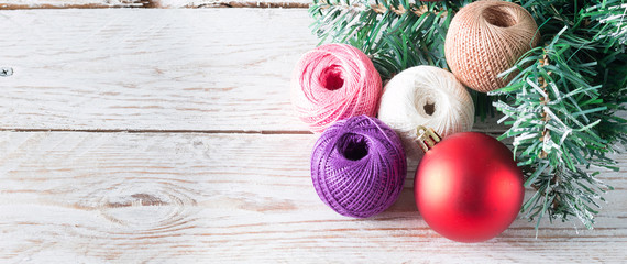 Christmas holiday composition. Eco-friendly cotton yarn. Skeins of thread on a light wooden table....