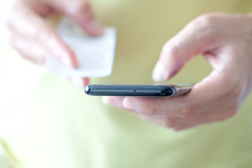 Women modern lifestyle she sat in the living room, she is spending The bill is in her hands and using his tablet pc and holding credit card her online To buy product and Pay debts in the internet