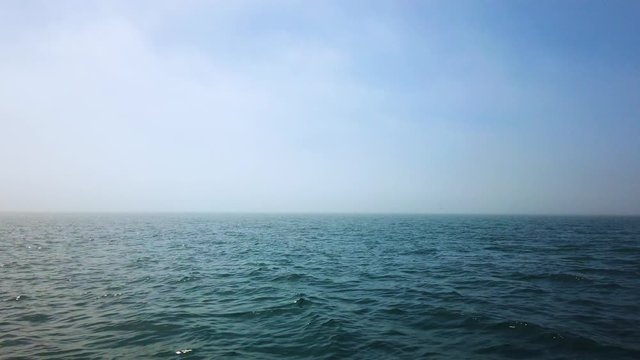 POV footage of open water on sunny day from boat, slomo