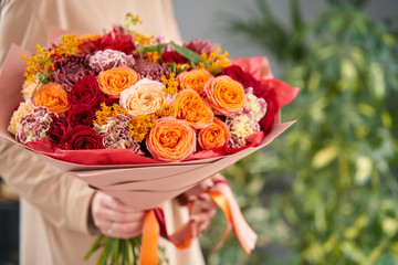 Beautiful bouquet of mixed flowers in womans hands. the work of the florist at a flower shop. Handsome fresh bouquet. Flowers delivery