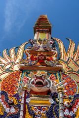 Bade cremation tower with traditional balinese sculptures of demons and flowers on central street...