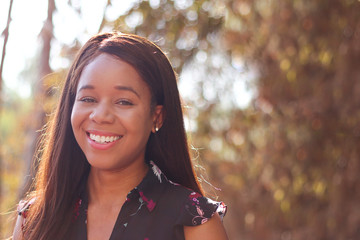 A laughing college-age African American woman looking forward into the camera.