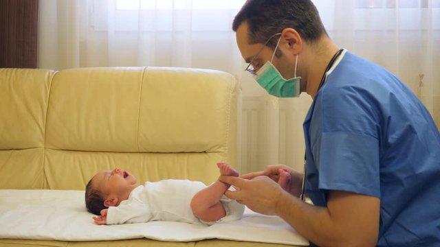 Doctor with uniform examining crying newborn baby child