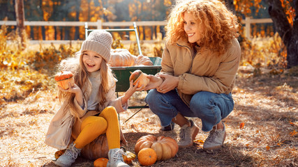 Mother spending autumn day on farm with her daughter