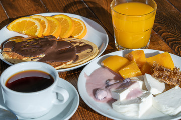Breakfast of many dishes and drinks on a wooden table, closeup. Food concept