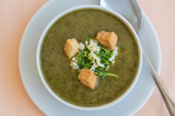 Green cream soup from spinach with croutons, cheese and fresh parsley