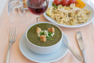 Green cream soup from spinach with croutons, cheese and fresh parsley