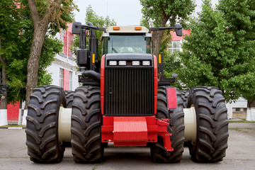 Obraz premium the back of a large tractor for farming freshly pickled red in a large plant after assembly on a summer day