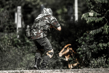 A soldier wearing a camouflage suit holding a gun