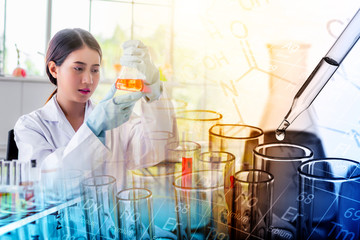 Attractive scientist woman looking chemical sample in flask at laboratory with lab glassware...