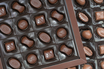 Brown chocolate candy background. Assortment of chocolate candies sweets in the box